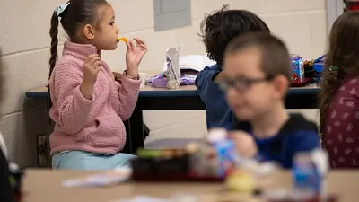 Children eating lunch together at a school table