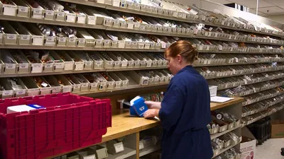 Pharmacy shelves stocked with medication boxes