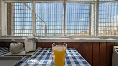 A glass of orange juice on a checkered tablecloth