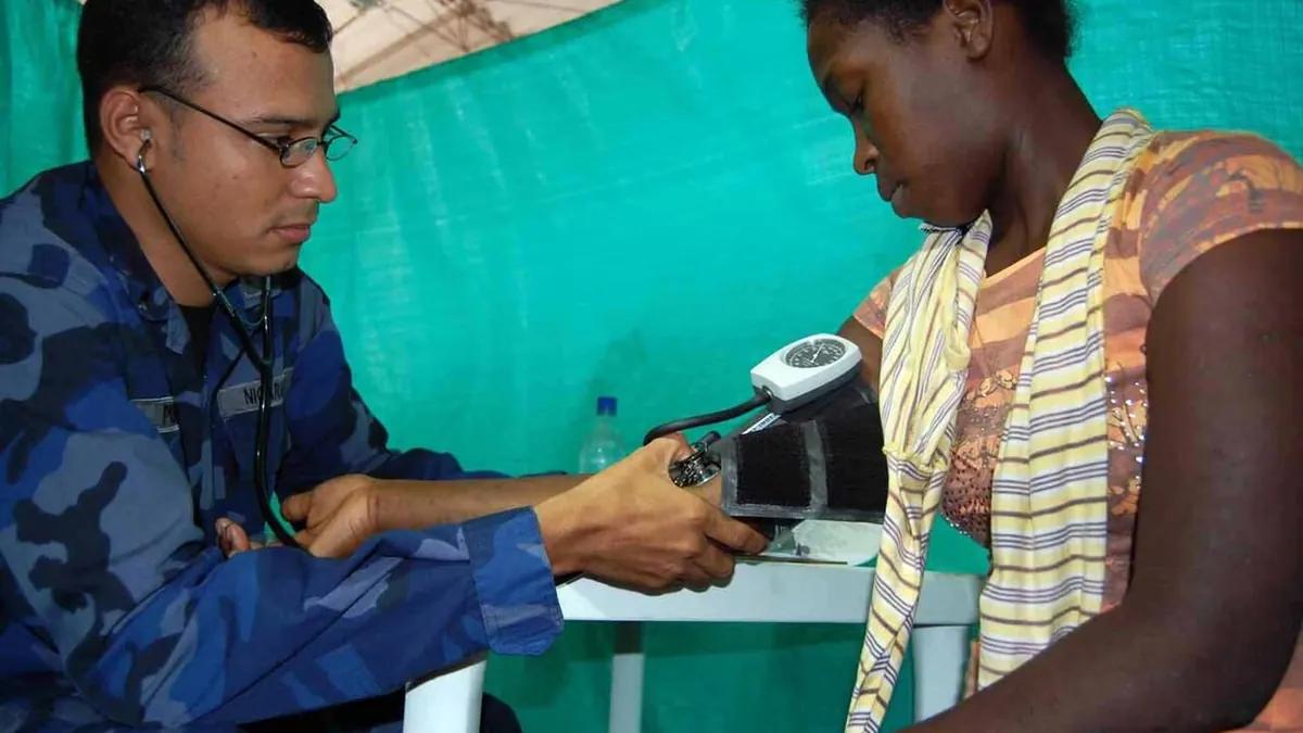 A health worker checking a woman's blood pressure during a screening visit