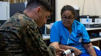 A health worker helping a patient check blood glucose with a meter